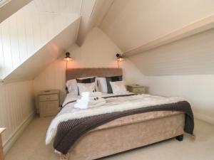 a bedroom with a large bed in a attic at Harriet's Cottage in Whitby