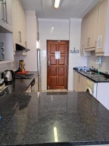 a kitchen with a black counter top and a wooden door at Dolphin View 402 Margate in Margate