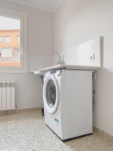 a washing machine in a laundry room with a window at Majordoms - Ca les Cosines 48 in Banyoles