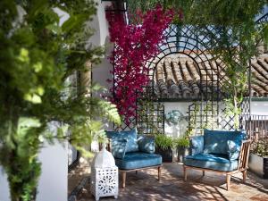 dos sillas azules sentadas en un patio con flores en Gandesa, Palace House en Sevilla