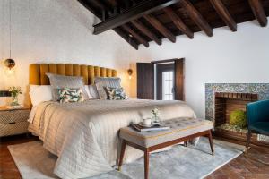 a bedroom with a large bed and a blue chair at Gandesa, Palace House in Seville +53 photos