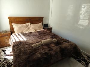 um quarto com uma cama com um cobertor castanho em Heaven of Fes em Fez