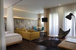 a living room with a yellow couch and a table at Mjus Resort & Thermal Park in Körmend
