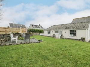 a house with a lawn in front of it at Halcyon Annexe in Moelfre