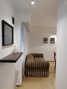 ein Wohnzimmer mit einem Stuhl und einem TV in der Unterkunft Depa 900 cómodo remodelado centro cerca de todo in Cordoba