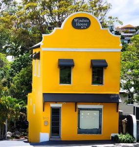 un bâtiment jaune avec un panneau sur lequel figure un panneau dans l'établissement Private Windsor House Studios Apartment, à Brisbane