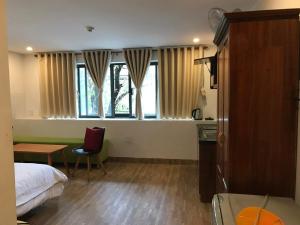 a bedroom with a bed and a table and a window at Danang Beach Homestay in Danang