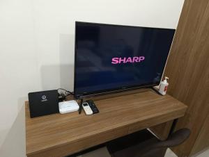 Une télévision à écran plat est installée au-dessus d'une table en bois. dans l'établissement Kozi Square Aurora Homestay L7, à Kuching