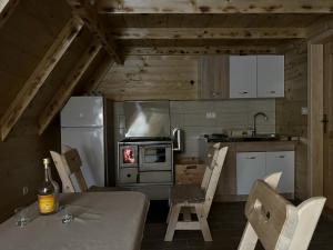 eine Küche mit einem Tisch und Stühlen sowie einem Kühlschrank in der Unterkunft Forest rest in Plužine