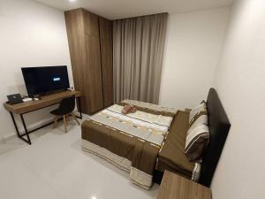 - une chambre avec un lit et un bureau avec une télévision dans l'établissement Kozi Square Aurora Homestay L7, à Kuching