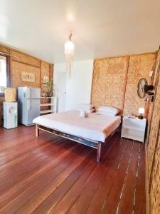 a bedroom with a large bed and a refrigerator at Family Cabana at Amihan Surf Cabanas in General Luna