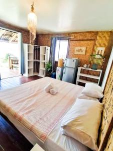 a large bed with two pillows in a room at Family Cabana at Amihan Surf Cabanas in General Luna