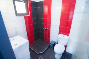 a bathroom with a toilet and a shower with red paint at Elafonisi Paradise with Parking, WiFi, - Walking Distance to the Beach in Elafonisi