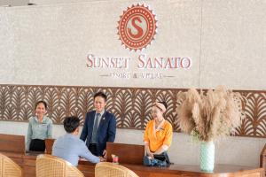 un groupe de personnes assises à une table dans un restaurant dans l'établissement Sunset Sanato Resort & Villas, à Duong Dong