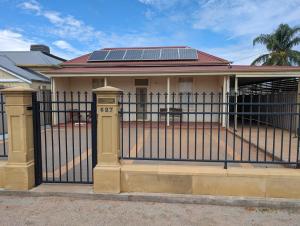 a house with solar panels on top of a gate at The Astra Broken Hill in Broken Hill