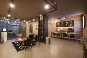 Una sala de estar con sillas y un comedor. en Hotel Gray, en Busan
