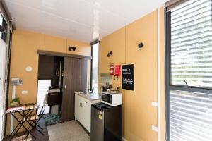 a small kitchen with a refrigerator and a microwave at Organic Farm Stay in Numurkah
