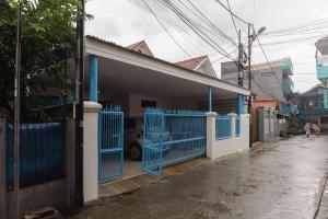 ein Haus mit einem blauen Tor auf einer Straße in der Unterkunft RedDoorz Syariah @ Sakura Hotel Jatiwaringin in Bekasi