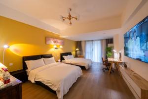 a hotel room with two beds and a large screen at 一抹云栖世博店-公寓民宿 Bed and Breakfast in Shanghai