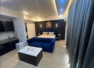 a bedroom with a bed and a blue couch at Royal Suites INN in Lucknow