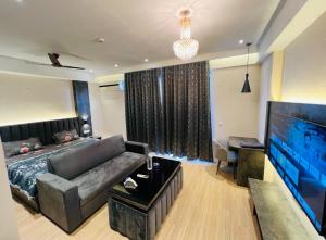 a living room with a couch and a flat screen tv at Royal Suites INN in Lucknow