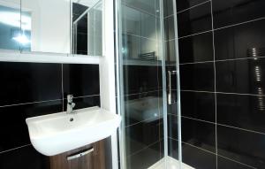 a bathroom with a sink and a glass shower at Rosina grove ebbsfleet in Swanscombe