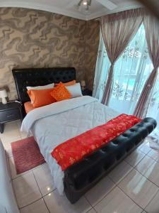 a bedroom with a large bed with orange pillows at Sbukosezwe guest house in Johannesburg