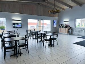 ein Restaurant mit Tischen und Stühlen in einem Zimmer in der Unterkunft Days Inn & Suites by Wyndham Santa Rosa, NM in Santa Rosa