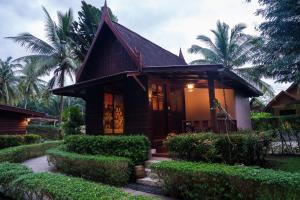 a small house with trees and bushes at Leeloo Paradise in Khanom