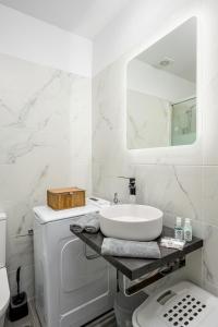 a white bathroom with a sink and a washing machine at Marillia's elegance residence in Mesaria
