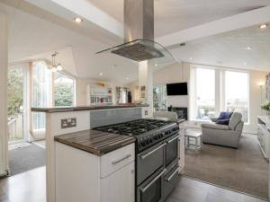 a kitchen with a stove top oven next to a living room at Oyster Bay Lodge in Dalbeattie