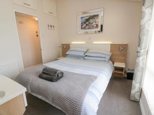 a bedroom with a large bed with a black bag on it at Oyster Bay Lodge in Dalbeattie