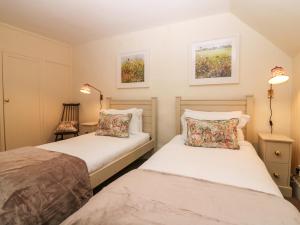 two beds in a small room with two lamps at North Mains Cottage - Craigievar Castle in Alford