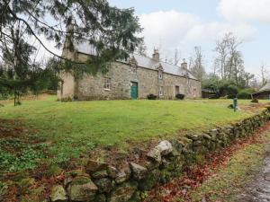 an old stone house with a stone wall at South Mains Cottage - Craigievar Castle in Alford