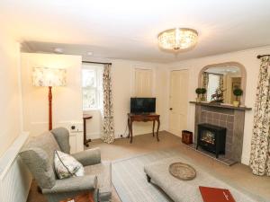 a living room with a couch and a fireplace at South Mains Cottage - Craigievar Castle in Alford