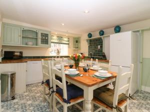 a kitchen with a wooden table and chairs in a kitchen at South Mains Cottage - Craigievar Castle in Alford