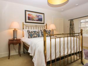 a bedroom with a bed and two lamps and a window at South Mains Cottage - Craigievar Castle in Alford