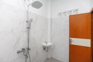 a bathroom with a shower and a sink at RedDoorz Syariah @ Sakura Hotel Jatiwaringin in Bekasi