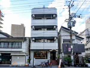 a tall blue building on a city street at 龙猫民宿-梅田店303 in Osaka