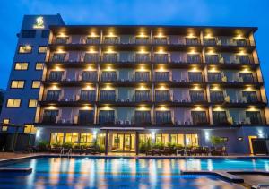 a hotel with a pool in front of it at Savotel Hotel in Na Jomtien