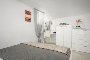 梅薩雷亞的住宿－Marillia's elegance residence，一间卧室配有一张床、梳妆台和书桌