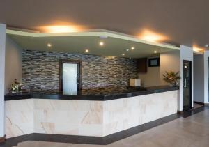 a lobby with a stone wall and a reception desk at Savotel Hotel in Na Jomtien