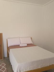 łóżko w pokoju z białą ścianą w obiekcie MHARI Bungalows & Studio Rooms w mieście Tubod