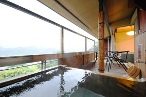 an indoor pool in a house with windows at Seizan Yamato in Ito