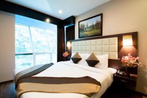 a bedroom with a large bed and a large window at Akshaya Aura in Bengaluru +109 photos