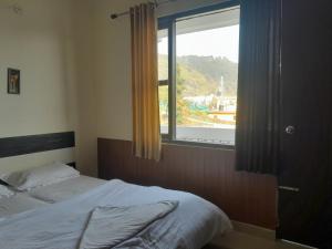 Bhowāli的住宿－New Sameer Hotel，一间卧室设有一张床和一个大窗户