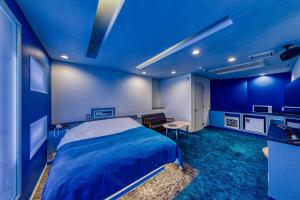 Hotel Cordon -Adult Only في أوساكا: غرفة نوم زرقاء مع سرير ومكتب