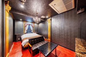 a bedroom with a bed and a black wall at Hotel Cordon -Adult Only in Osaka