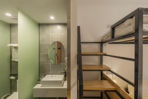 een badkamer met een stapelbed, een wastafel en een spiegel bij Fangorn Hostel in Chongqing