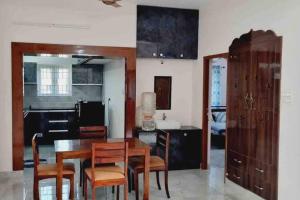 uma sala de jantar com mesa e cadeiras e uma cozinha em Apartment near LNT & CTC & Airport - 3F em Chennai